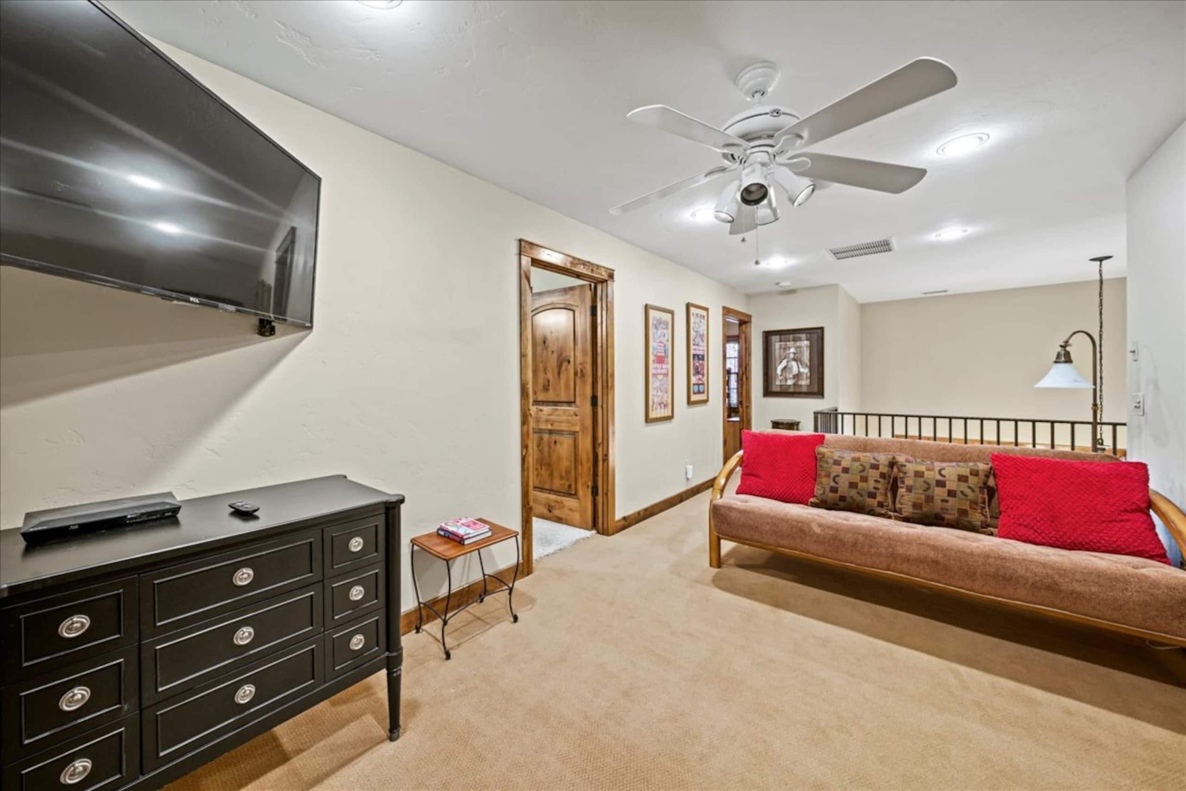 A dresser, TV and red futon in the loft