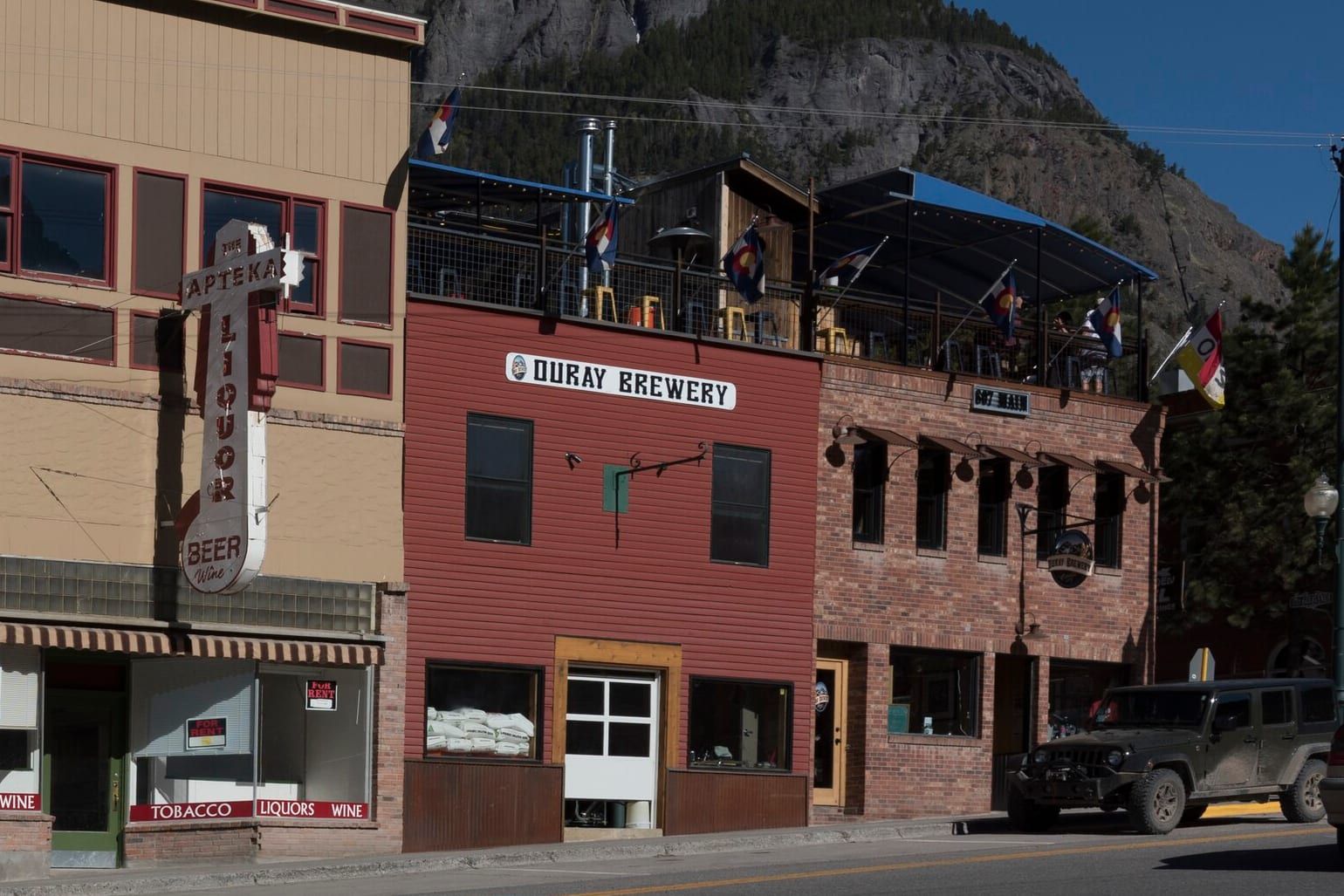 The red Ouray Brewery building and its rooftop patio on Main Street