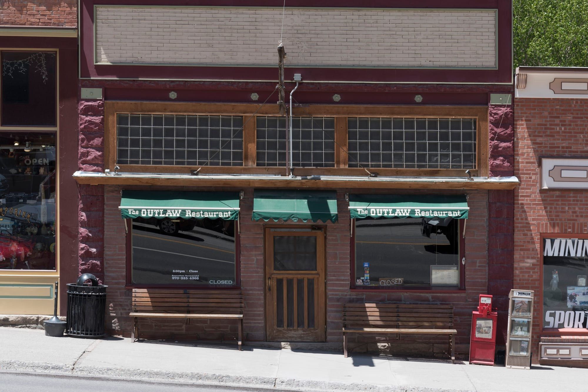 The brick front of the Outlaw Restaurant with its green awnings