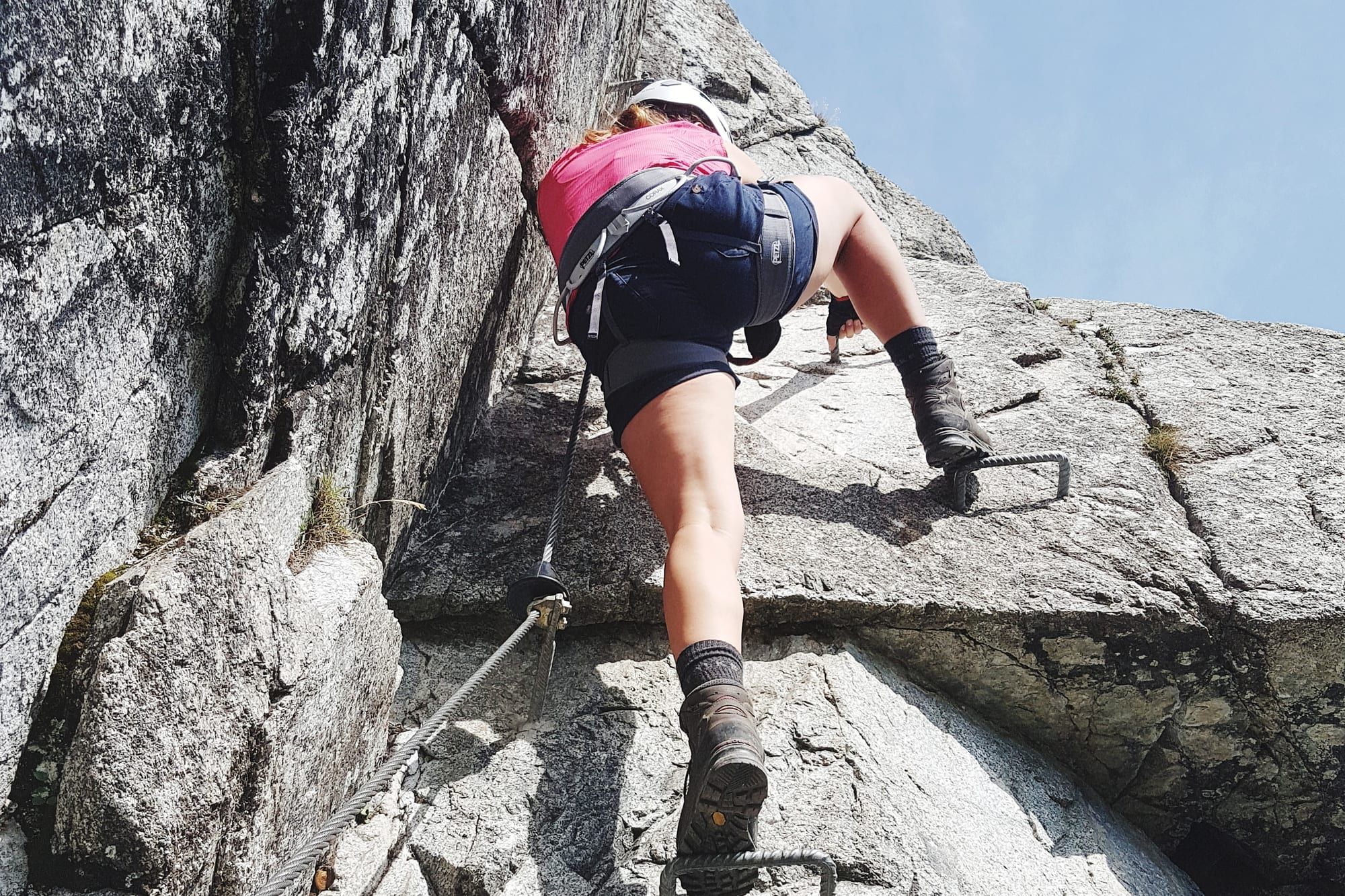 A climber on the steel rungs and cable of a via ferrata